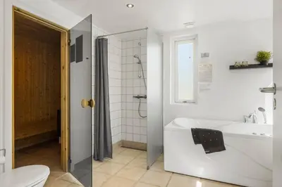 a bathroom with a tub and a toilet and a sink at JB328-Brovst-Kronvildtvej-184 in Brovst