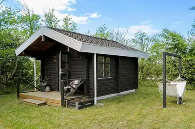 a small black shed with a porch and a swing at JB161-Brovst-Kronvildtvej-206 in Brovst