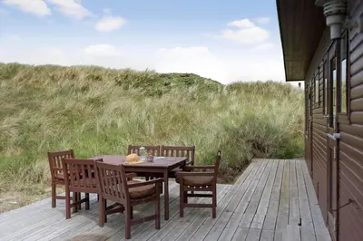 a wooden table and chairs on a wooden deck at JB233-Brovst-Ejstrup-Strandvej-24 in Brovst