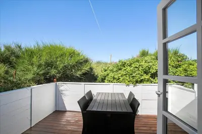 a table and chairs on a wooden deck with a door at JB116-Frostrup-Svenstibakkevej-30 in Frøstrup
