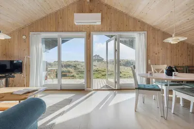 a living room with a table and chairs and sliding glass doors at JB173-Brovst-Redningsvejen-28 in Brovst