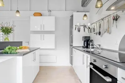 a kitchen with white cabinets and black counter tops at JB178-Brovst-Kronvildtvej-3 in Brovst