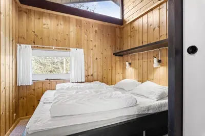 a large bed in a wooden room with a window at JB987-Fjerritslev-N-C-Alstedsvej-12 in Fjerritslev