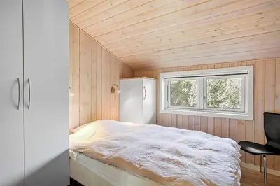 a small bedroom with a bed and a window at JB133-Fjerritslev-Blabaerstien-35 in Fjerritslev