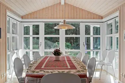 a dining room with a table and white chairs at JB133-Fjerritslev-Blabaerstien-35 in Fjerritslev