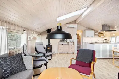 a living room with a table and chairs and a kitchen at JB137-Fjerritslev-Markstien-15 in Fjerritslev