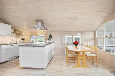 a kitchen with a table and a table and chairs at JB137-Fjerritslev-Markstien-15 in Fjerritslev