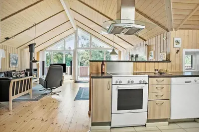 a kitchen with a stove and a living room at JB223-Brovst-Kronvildtvej-18 in Brovst