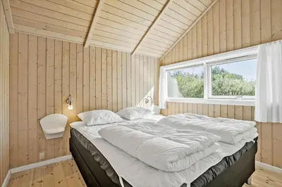 a large bed in a room with a window at JB223-Brovst-Kronvildtvej-18 in Brovst