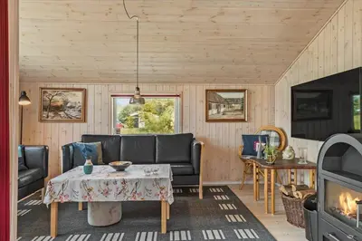 a living room with a couch and a table and a fireplace at JB166-Fjerritslev-Egevej-26 in Fjerritslev