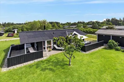 a house with a black roof and a green yard at JB166-Fjerritslev-Egevej-26 in Fjerritslev