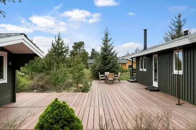 a patio with a wooden deck next to a house at JB115-Fjerritslev-Blabaerstien-9 in Fjerritslev