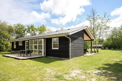 a black tiny house with a picnic table in a yard at JB324-Fjerritslev-Tyttebaerstien-42 in Fjerritslev