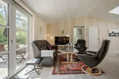 a living room with leather chairs and a table and a television at JB324-Fjerritslev-Tyttebaerstien-42 in Fjerritslev