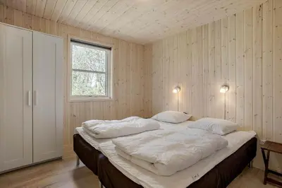 a bedroom with a large bed with two pillows at JB324-Fjerritslev-Tyttebaerstien-42 in Fjerritslev