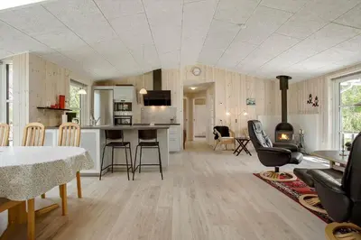 a kitchen and living room with a table and chairs at JB324-Fjerritslev-Tyttebaerstien-42 in Fjerritslev