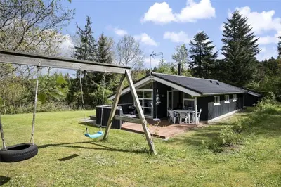 a black cabin with a porch and a swing at JB243-Fjerritslev-Aspevej-1 in Fjerritslev