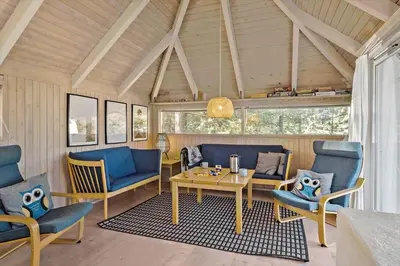 a living room with blue chairs and a table at JB628-Fjerritslev-Lynghojsletten-49 in Fjerritslev