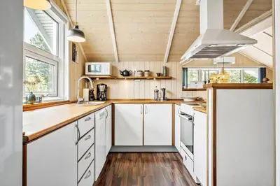 a kitchen with white cabinets and white appliances at JB303-Fjerritslev-Tyttebaerstien-50 in Fjerritslev