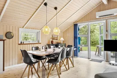 a dining room with a table and chairs at JB303-Fjerritslev-Tyttebaerstien-50 in Fjerritslev