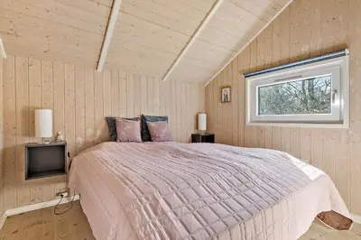 a bedroom with a large bed and a window at JB303-Fjerritslev-Tyttebaerstien-50 in Fjerritslev