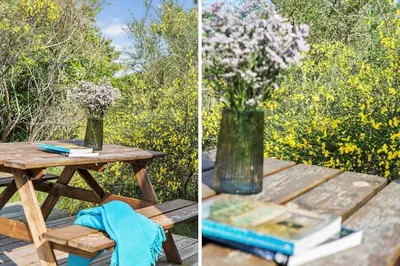 a picnic table with a vase of flowers and books at JB1108-Frostrup-Strandvejen-67 in Frøstrup