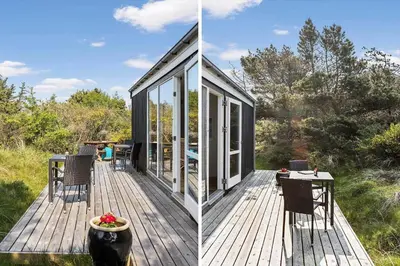 a house with glass doors and a table on a deck at JB1108-Frostrup-Strandvejen-67 in Frøstrup
