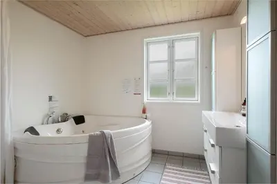 a white bathroom with a large tub and a sink at JB283-Frostrup-Andreas-Lassens-Vej-6 in Frøstrup