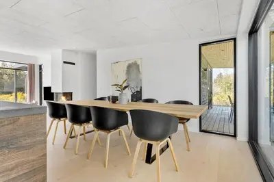 a dining room with a wooden table and black chairs at JB190-Fjerritslev-Stenhusvej-34-B in Fjerritslev