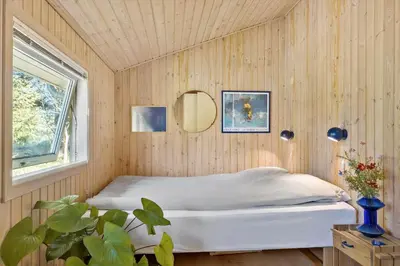 a bedroom with a bed in a wooden wall at JB291-Fjerritslev-Stenhusvej-30 in Fjerritslev
