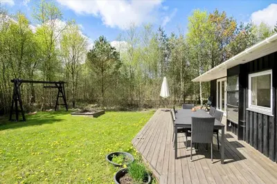 a wooden deck with a table and chairs in a yard at JB167-Fjerritslev-Revlingestien-83 in Fjerritslev