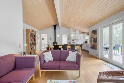 a living room with a purple couch and a dining room at JB167-Fjerritslev-Revlingestien-83 in Fjerritslev
