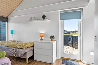 a bedroom with a bed and a sliding glass door at JB169-Brovst-Kronvildtvej-126 in Brovst