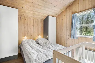 a bedroom with a bed in a wooden wall at JB255-Fjerritslev-Blabaerstien-22 in Fjerritslev