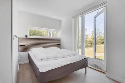 a white bedroom with a bed and a window at JB221-Brovst-Kronvildtvej-182 in Brovst
