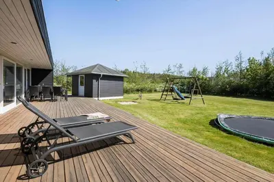 a wooden deck with a swing set and a playground at JB221-Brovst-Kronvildtvej-182 in Brovst