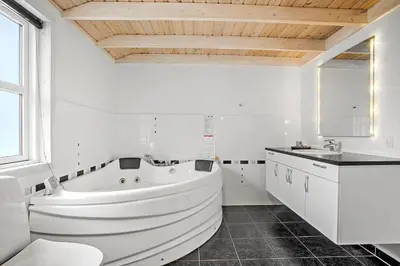 a white bathroom with a tub and a sink at JB888-Fjerritslev-Aspevej-15 in Fjerritslev
