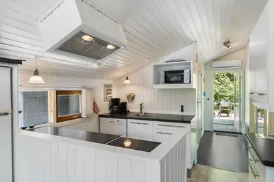 a kitchen with white cabinets and a black counter top at JB272-Fjerritslev-Ronnevej-14 in Fjerritslev