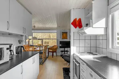 a kitchen with white cabinets and a dining room at JB179-Fjerritslev-Slojbrovej-77 in Fjerritslev