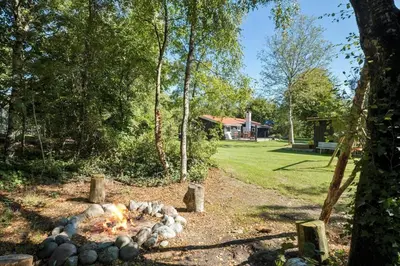 a fire pit in a yard with a house in the background at JB179-Fjerritslev-Slojbrovej-77 in Fjerritslev