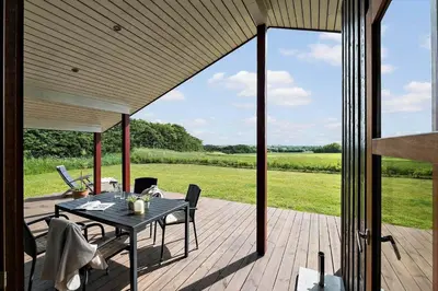 a patio with a table and chairs on a deck at JB188-Fjerritslev-Kollerup-Klitvej-163 in Fjerritslev
