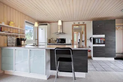 a kitchen with a bar with a chair in it at JB313-Fjerritslev-Fiskerstien-7 in Fjerritslev