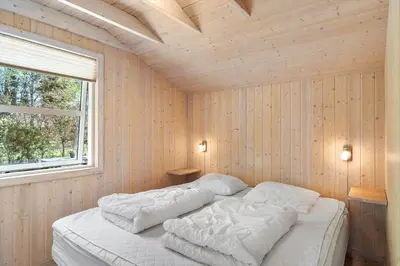 a bedroom with a bed with white sheets and a window at JB251-Fjerritslev-Egevej-5 in Fjerritslev