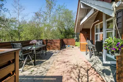 a patio with a table and chairs on a house at JB198-Fjerritslev-Tyttebaerstien-40 in Fjerritslev