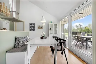 a kitchen and dining room with a white table and chairs at JB752-Brovst-Kronvildtvej-210 in Brovst