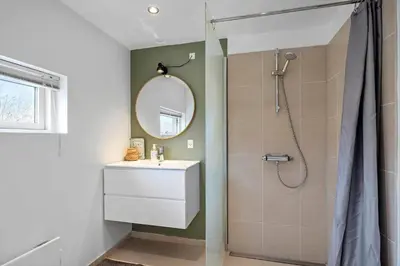 a bathroom with a sink and a shower with a mirror at JB752-Brovst-Kronvildtvej-210 in Brovst