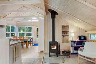 a wood stove in a living room with a table at JB138-Fjerritslev-C-J-Thaningsvej-3 in Fjerritslev