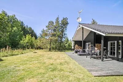 a black house with a patio and a yard at JB295-Brovst-Ildervej-7 in Brovst