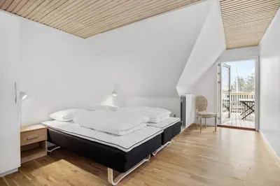 a white bedroom with a bed and a table at JB200-Fjerritslev-Udklitvej-168 in Fjerritslev