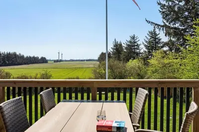 a table and chairs on a deck with a view of a field at JB200-Fjerritslev-Udklitvej-168 in Fjerritslev